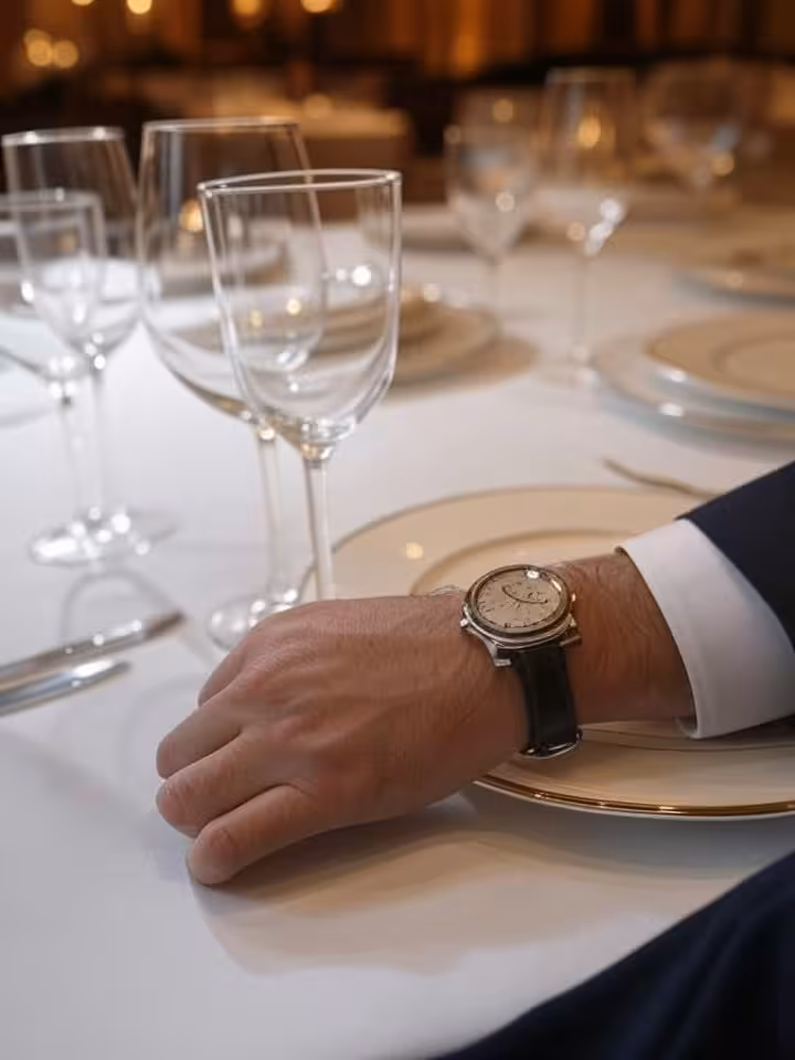 Cena elegante en restaurante con estrella Michelin mostrando reloj Cartier Santos